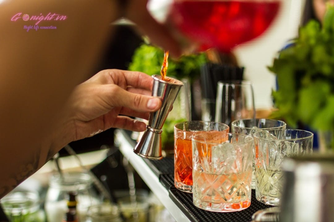 bartender pouring a colorful cocktail