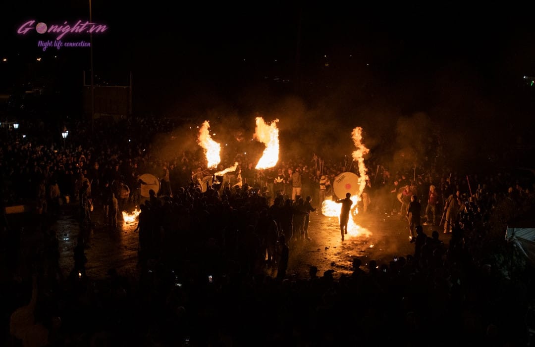 beach party at night with people dancing around a bonfire