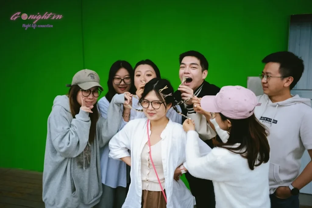 a group of people standing in front of a green screen