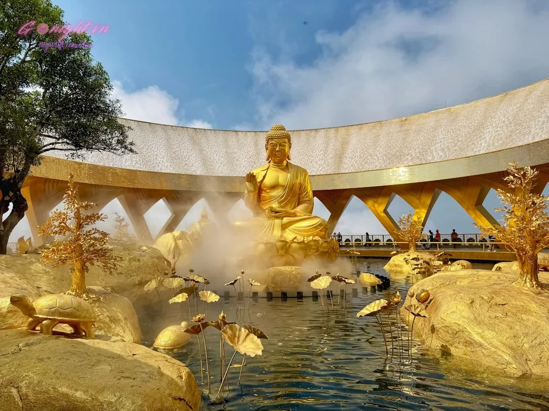 Golden buddha statue surrounded by water and golden rocks.