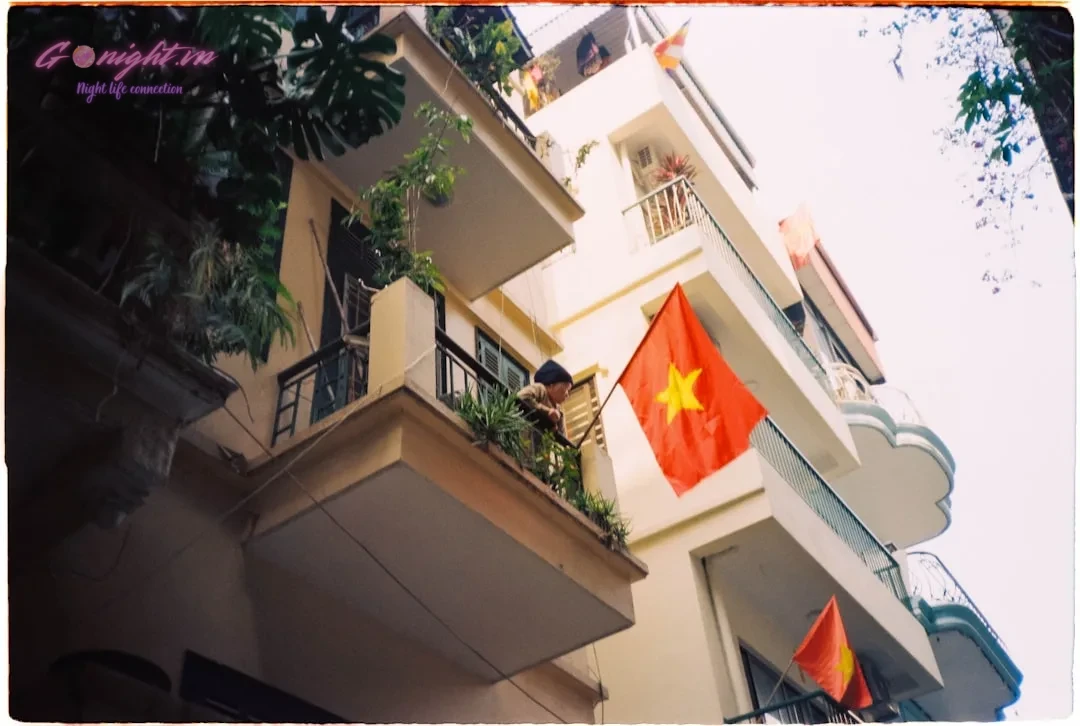 A building with vietnamese flags hanging from balconies.