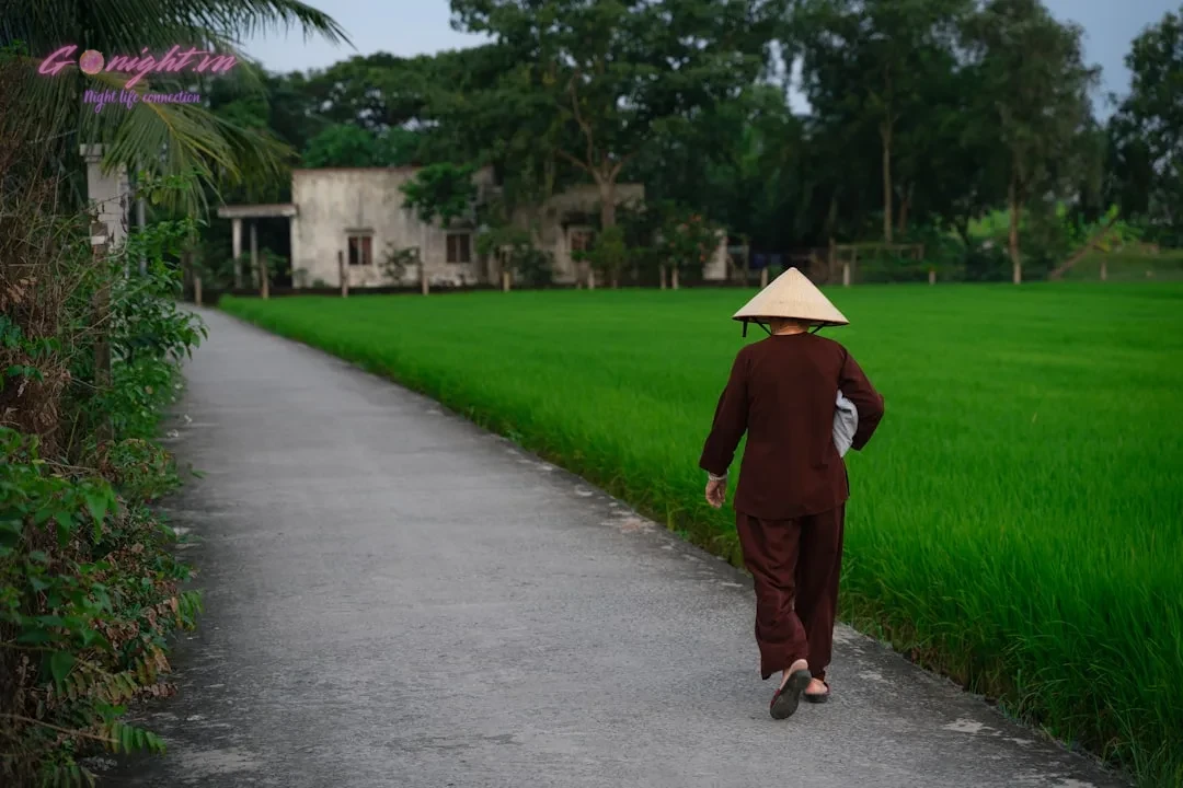 a person walking down a path with a hat on