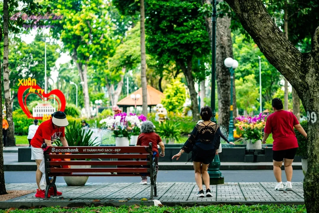 People exercising in a sunny park with flowers.