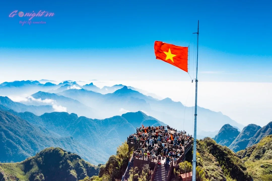a large group of people standing on top of a mountain