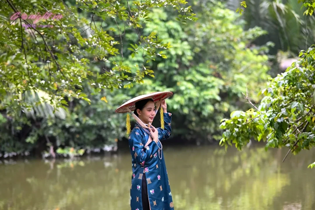 Tại Sao Massage Geisha Hà Đông Luôn “Hot” Nhất Khu Vực? 4 a woman in a blue kimono is holding a umbrella over her head