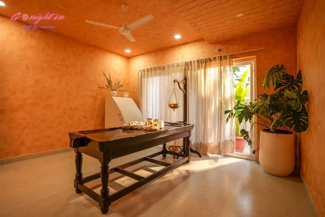 Bí Quyết Chọn Loại Hình Massage Phù Hợp Cho Từng Nhu Cầu: Từ Thư Giãn Sâu Đến Phục Hồi Năng Lượng Tức Thì 2 A massage table in a spa room with orange walls.