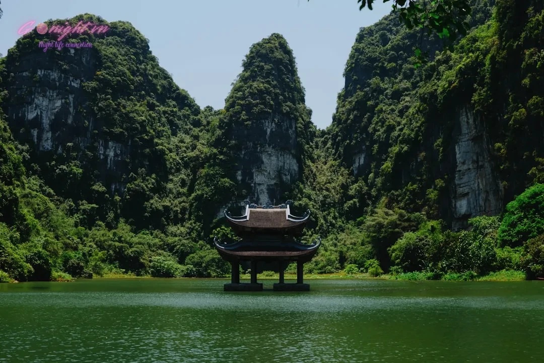 a pagoda in the middle of a lake surrounded by mountains