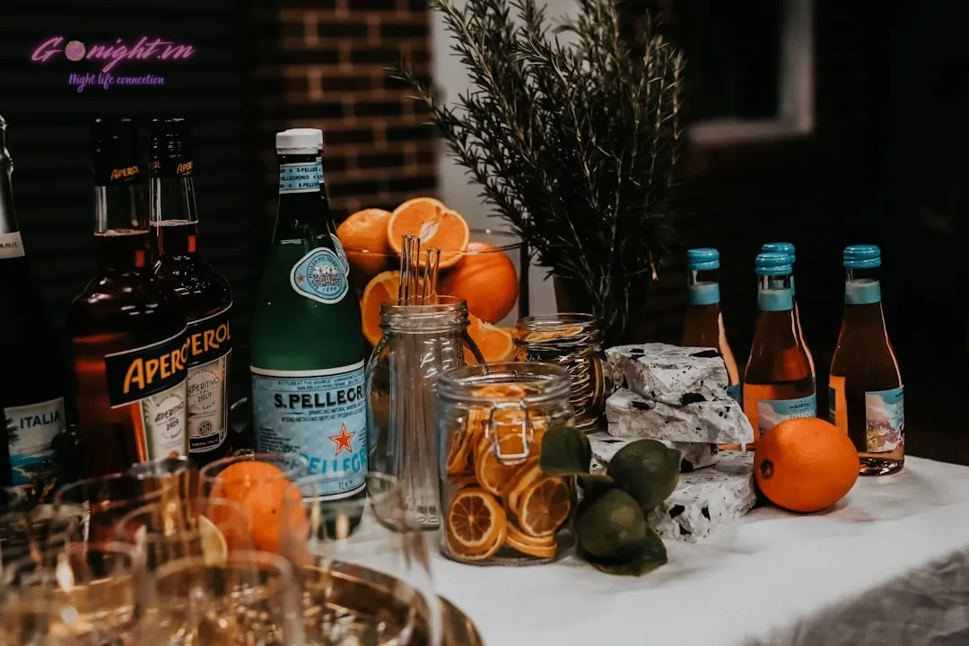 a table topped with bottles of alcohol and oranges