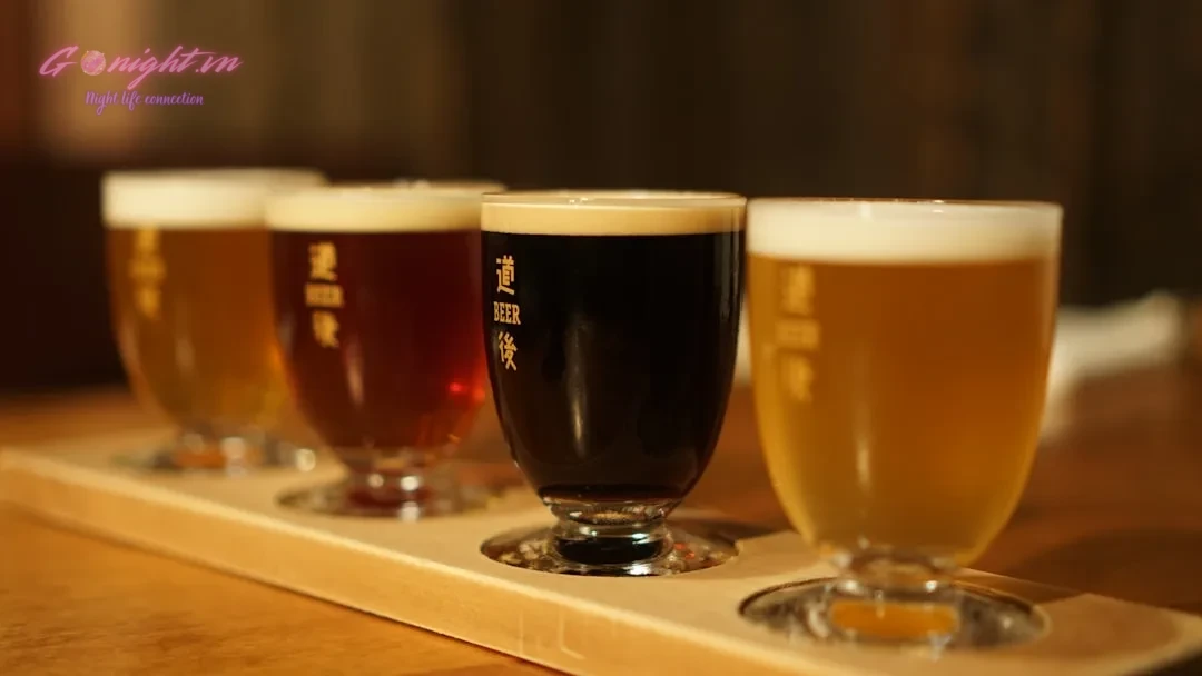 a row of beer glasses sitting on top of a wooden table
