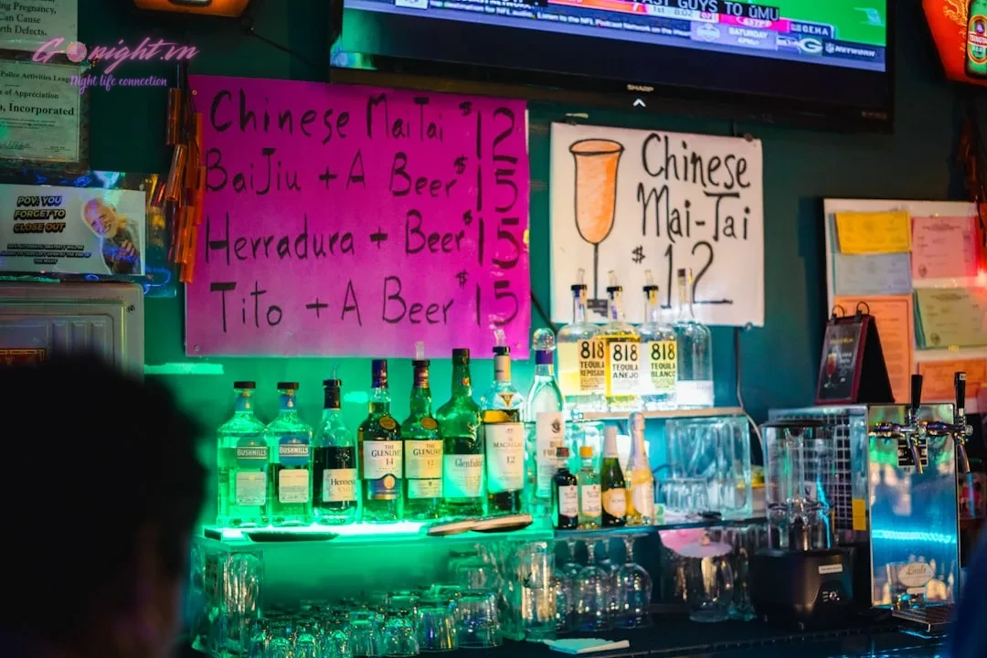 Ho Chi Minh City's Sky-High Escapes: Top 7 Rooftop Bars with Breathtaking Views 6 Bar counter with bottles and drink specials signs.