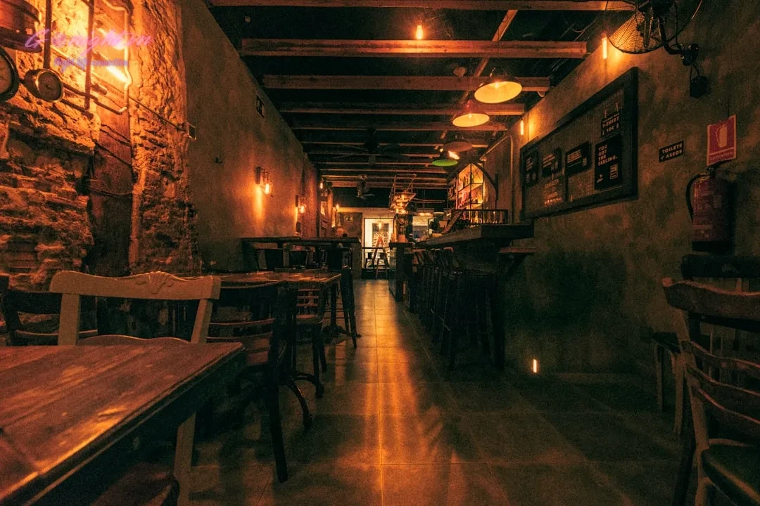 Top 7 Quán Pub Phố Cổ Hà Nội: Điểm Hẹn Lý Tưởng Cho Đêm Chill Cùng Bạn Bè 5 a dimly lit restaurant with wooden tables and chairs