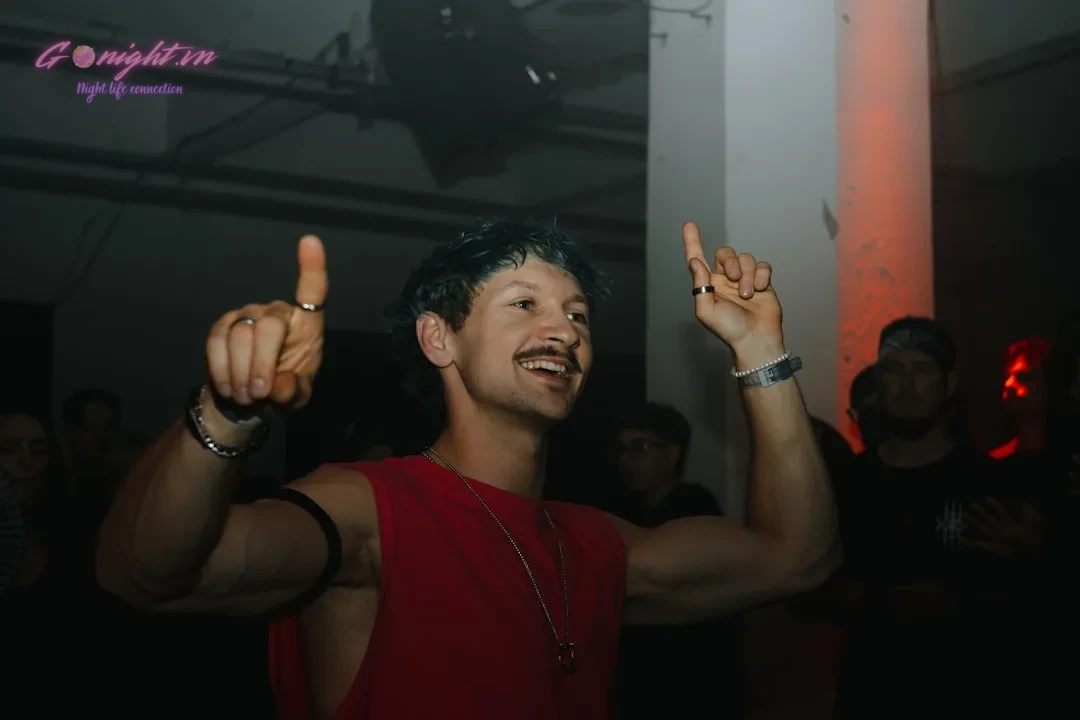 Man with mustache raising fingers at party