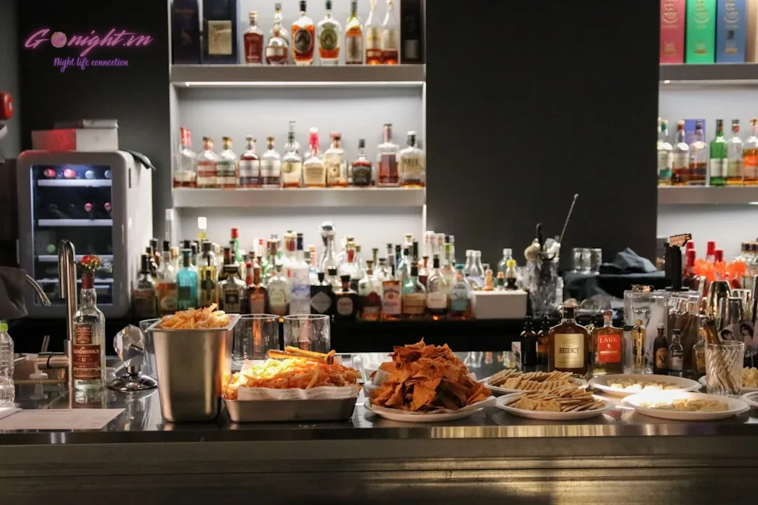 Hanoi's Elite Sips: Discovering the Top 7 Luxury Cocktail Lounges for a Sophisticated Night Out 8 A bar counter with drinks and food