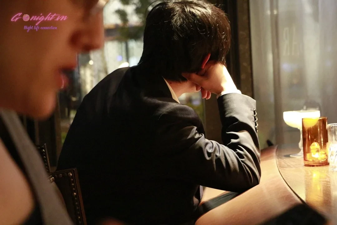 Man in suit resting head on hand at bar