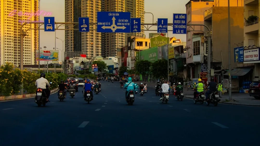 A group of people riding motorcycles down a street
