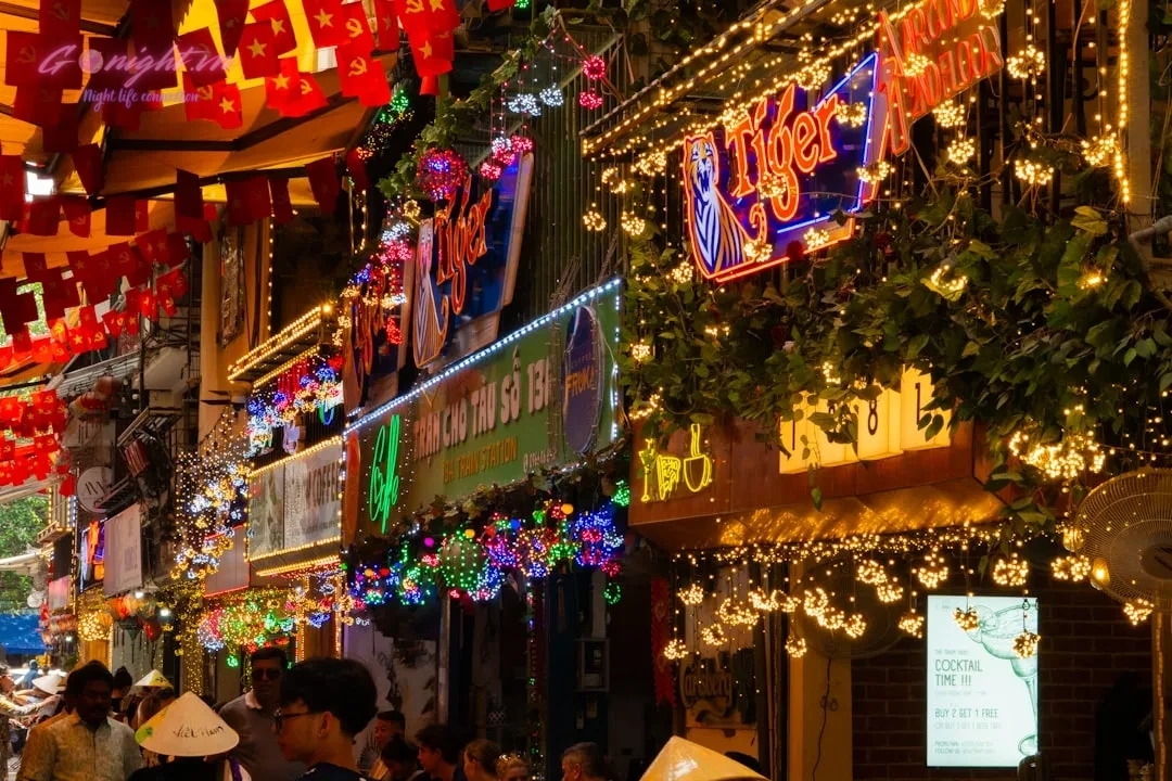 Hanoi's Secret Sips: Top 7 Hidden Speakeasy & Unique Concept Bars in Ba Dinh and Hoan Kiem 1 A vibrant street scene illuminated by festive lights.