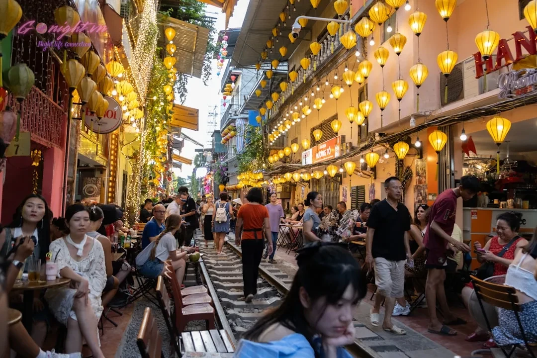 Top 7 Quán Pub Phố Cổ Hà Nội: Điểm Hẹn Lý Tưởng Cho Đêm Chill Cùng Bạn Bè 1 A group of people walking down a street next to tall buildings