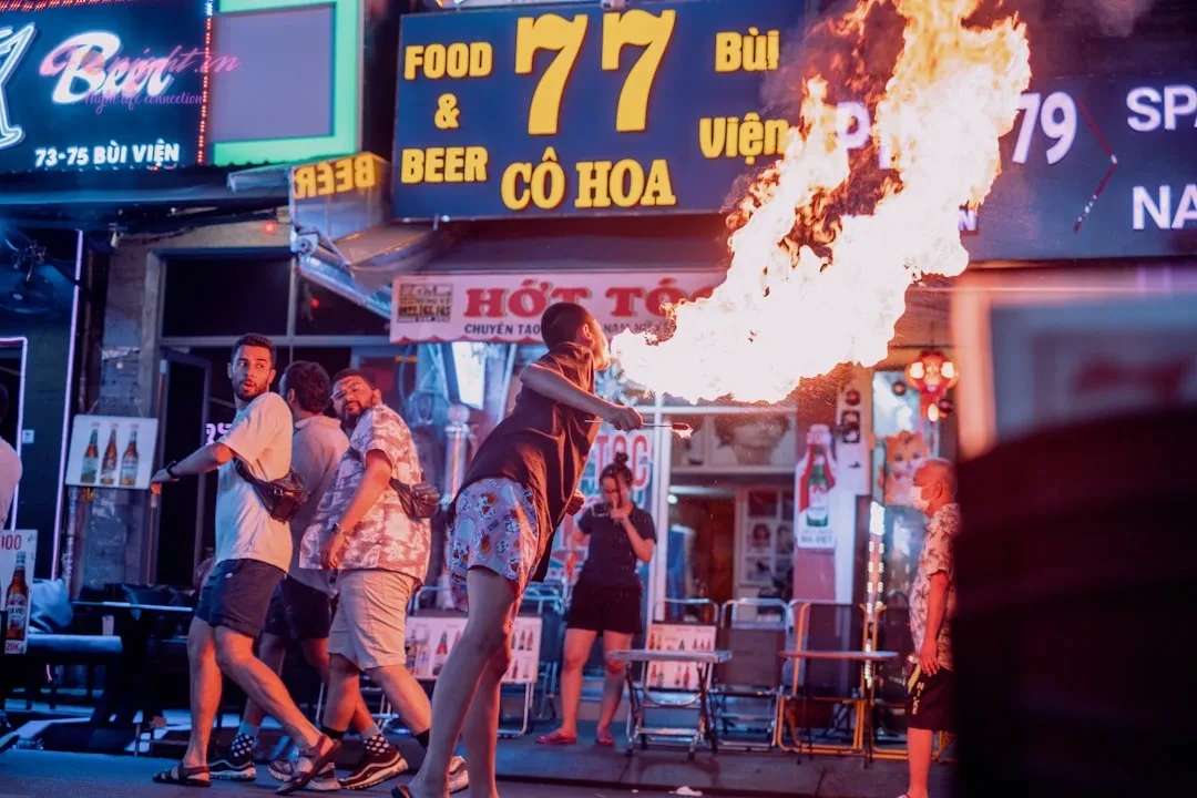 a group of people standing around a fire pit