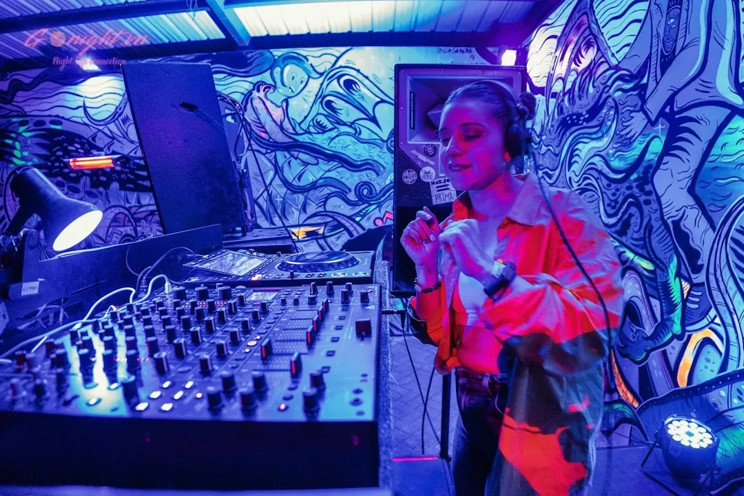 a woman standing in front of a mixing desk
