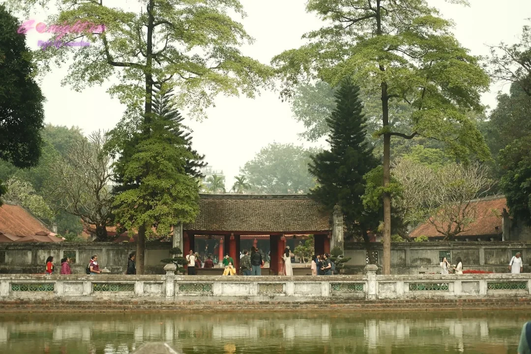 Khám Phá Top Địa Điểm Massage Văn Khê Hà Đông Mang Lại Trải Nghiệm Thư Giãn Đỉnh Cao 1 People stroll near an old temple and lake.