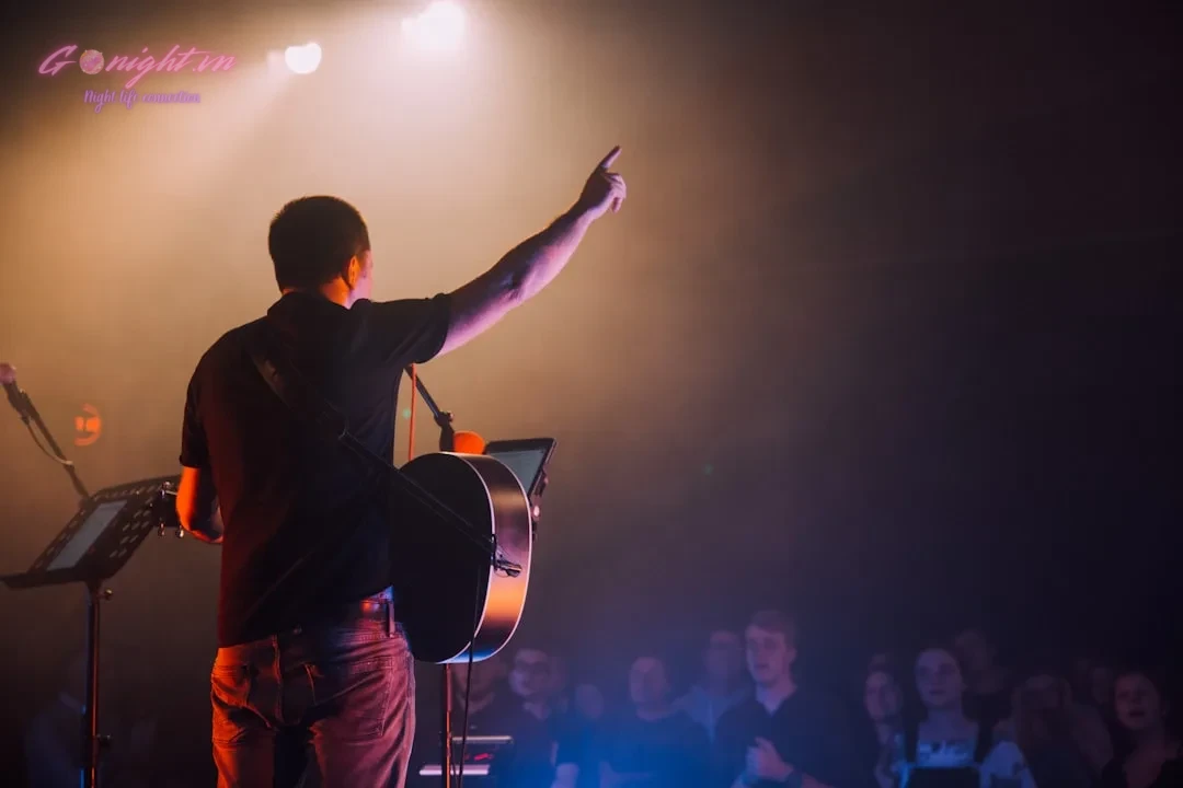man in black long sleeve shirt and red pants standing on stage