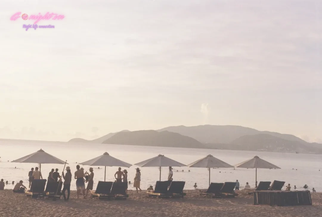 a group of people stand near each other on a beach