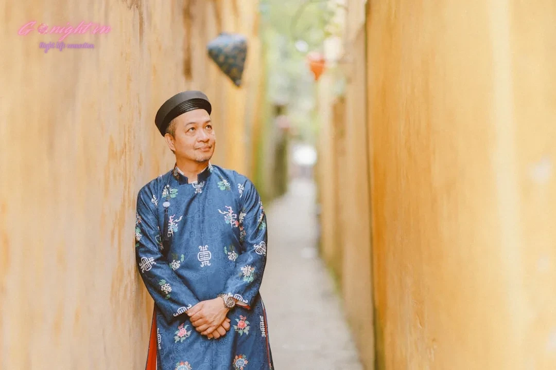 Man in traditional blue outfit in narrow alley.