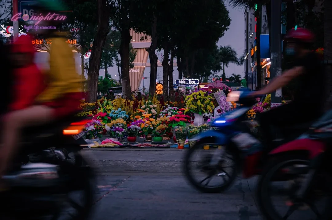 a couple of people riding motorcycles down a street