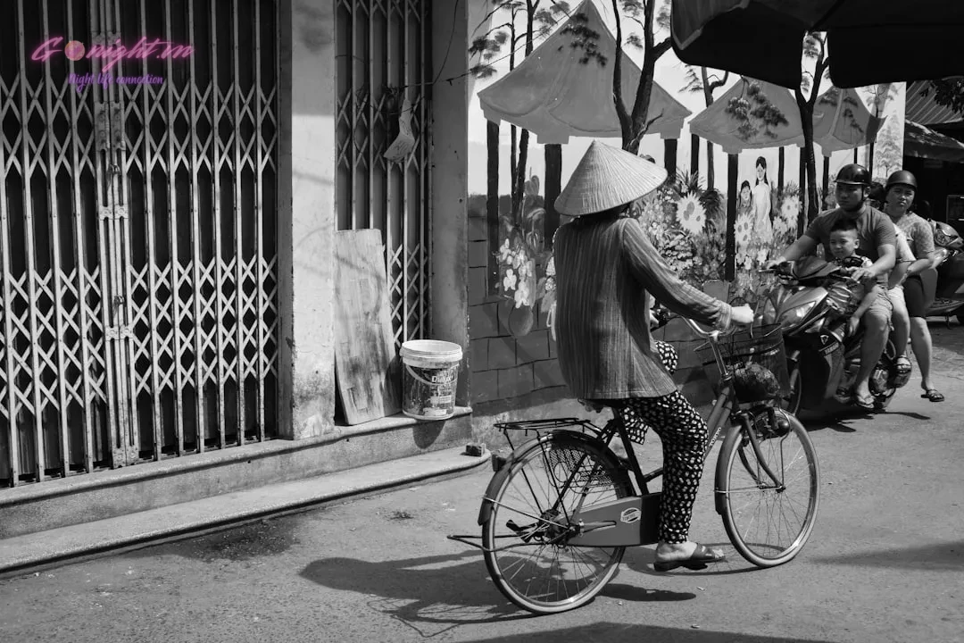 Beyond the Glass: A Guide to Exploring Unique Local Flavors in Vietnamese Craft Cocktails 6 woman in white dress holding umbrella walking on sidewalk in grayscale photography