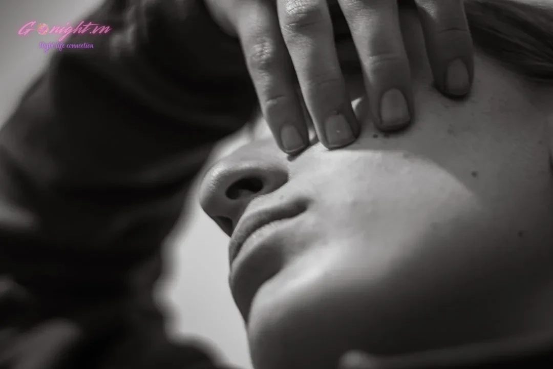 Close-up of a person's face with hand covering eye