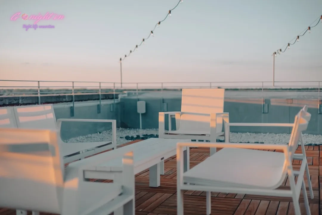 Giải Mã Mê Cung Nightlife: Khi Nào Nên Chọn Beer Club, Khi Nào 'Lên Đồ' Đi Rooftop Bar? 10 a deck with chairs and tables on it