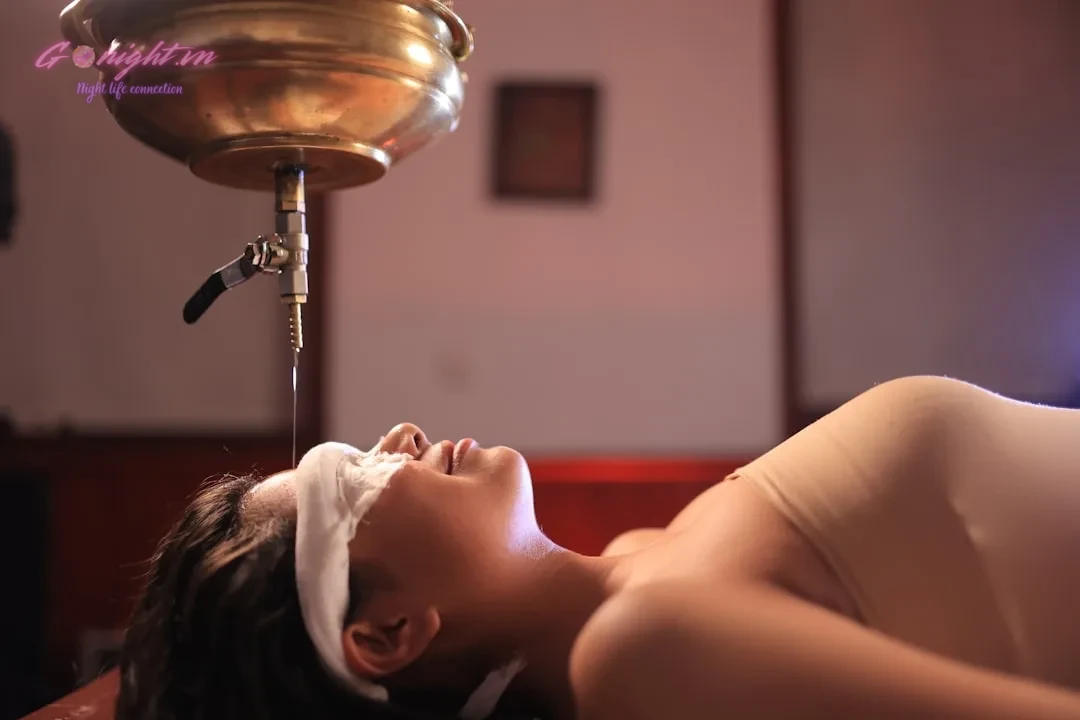 Woman receiving oil treatment on her forehead