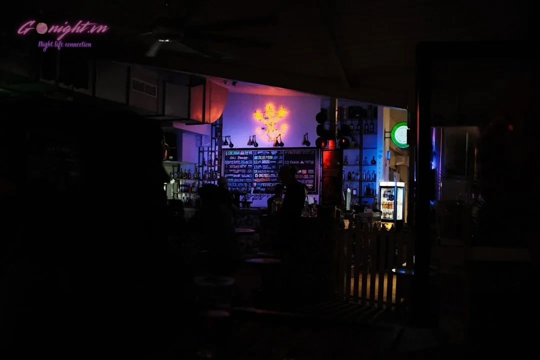 Top 7 Quán Cocktail Speakeasy và Hidden Bar Độc Đáo Khắp Việt Nam: Khám Phá Thế Giới Đồ Uống Nghệ Thuật 1 a man standing in a dark room next to a bar
