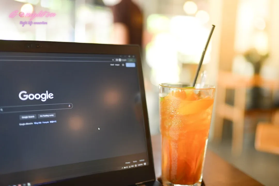 Top 7 Cocktail Bars in Ho Chi Minh City's District 1 for a Sophisticated Evening 5 a glass of orange juice next to a laptop computer