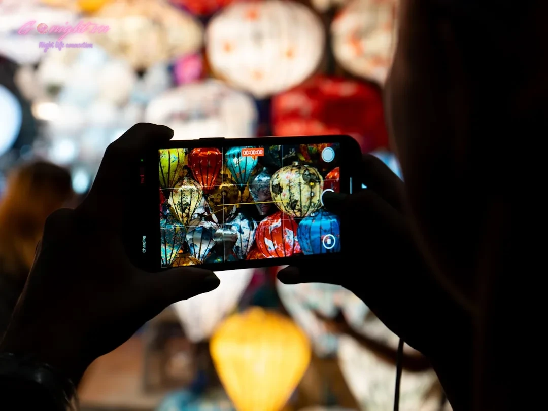 Person taking a picture of colorful lanterns with phone