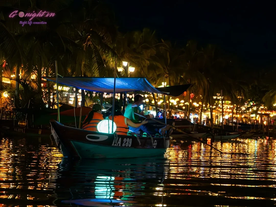 Navigating Vietnam's Nightlife: A Guide to Tipping Etiquette and Local Customs 1 Boat with illuminated lanterns on a river at night.