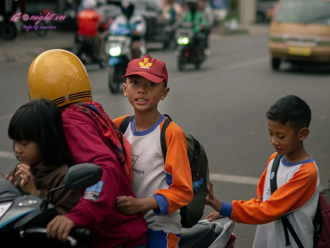 Children riding on a motorcycle in traffic